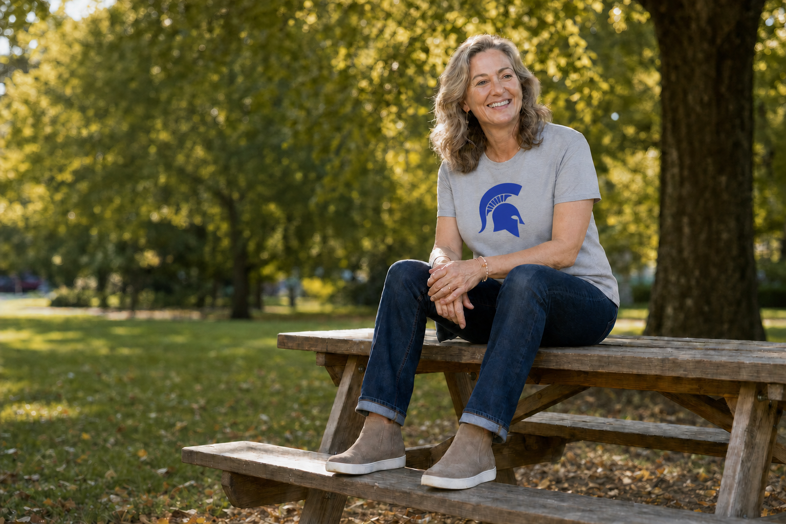 A Richmond Heights Schools teacher smiling on a picnic table on a warm fall day